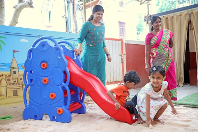 Children playing on slide in sand pit