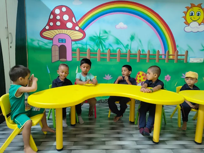 Children seated at classroom table under mural