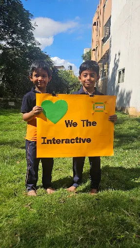 Children holding an iNTERACTiVE welcome sign