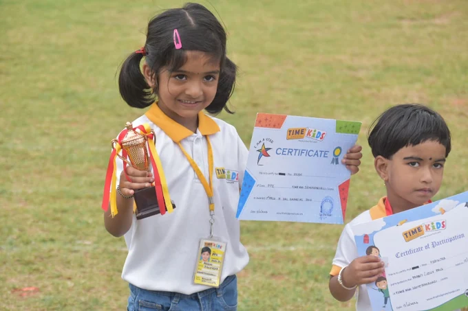 Girl proudly holding a trophy and certificate