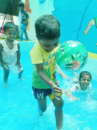 Children splashing and playing ball in a pool