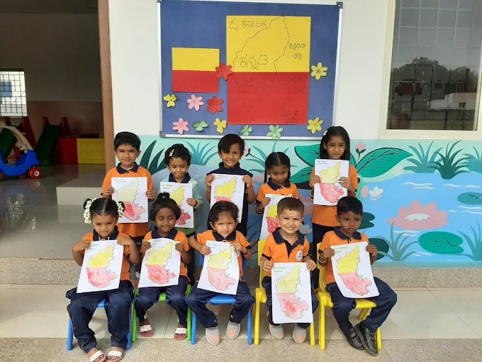 Children holding up hand-drawn Karnataka maps