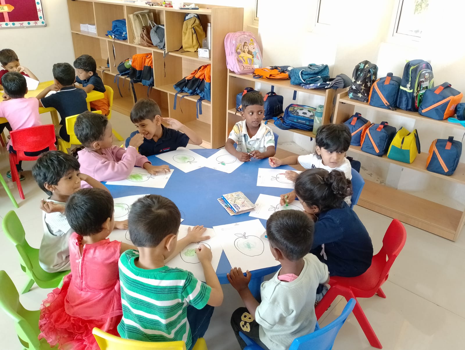 Teacher guiding LKG children